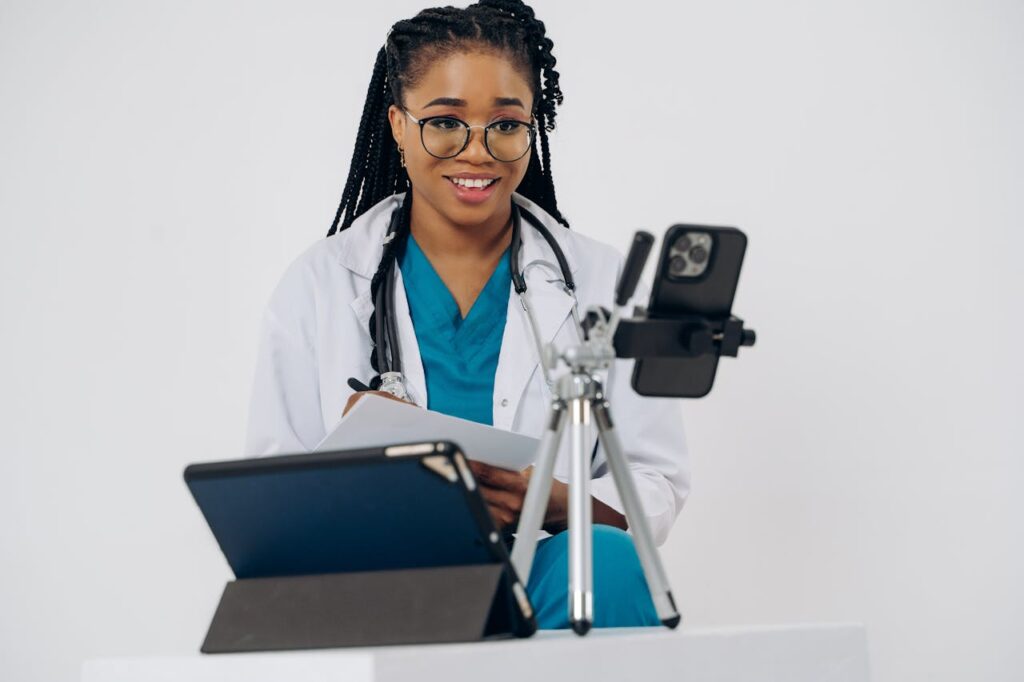 A female doctor is smiling while holding a tablet